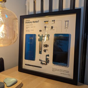 May include: A framed image of a disassembled Samsung Galaxy Note 7 smartphone. The image shows the phone's components, including the camera, battery, and motherboard. The text on the image reads "As it turns out, using it underwater is the only safe way to use a Galaxy Note 7." - Paul Thurrott on Twitter.