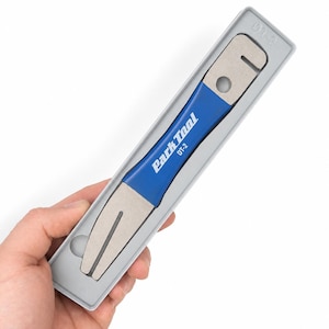 May include: A blue and silver Park Tool DT-2 rotor truing fork housed in a grey plastic storage tray. The tool features a metallic finish with a central blue handle section, clearly displaying the brand name and model number in white text.