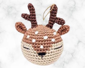 Puede incluir: Un adorno de ciervo de crochet marrón y blanco con un lazo de hilo marrón para colgar. El ciervo tiene una nariz blanca y manchas blancas en la cara. El texto "Deer Ornament" está por encima del ciervo y el texto "BKT Digital" está por debajo del ciervo.