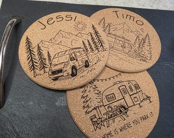 Puede incluir: Tres posavasos redondos de corcho con diseños grabados en negro. Un posavasos tiene una furgoneta camper con el nombre "Jessi", otro tiene una furgoneta camper con el nombre "Timo", y el tercero tiene el texto "HOME IS WHERE YOU PARK IT".