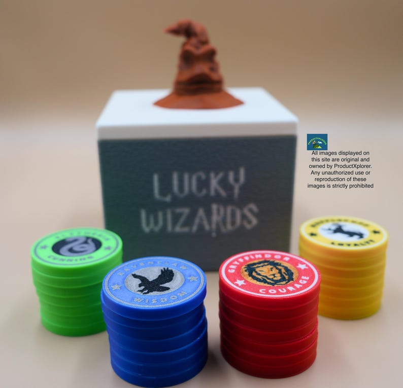 Pu&ograve; includere: Un set di gettoni da gioco colorati con diversi stemmi di casa e le parole "Saggezza" e "Coraggio" stampate su di essi. I gettoni sono impilati davanti a una scatola bianca con le parole "Lucky Wizards" stampate su di essa. Un Cappello Smistatore marrone si trova sopra la scatola.