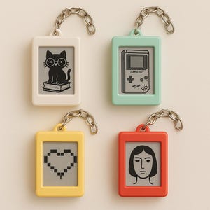 Peut inclure: Quatre porte-cl&eacute;s rectangulaires en blanc, vert menthe, jaune et rouge. Chaque porte-cl&eacute;s a une cha&icirc;ne argent&eacute;e et un graphisme diff&eacute;rent : un chat avec des lunettes, une Gameboy, un c&oelig;ur pix&eacute;lis&eacute; et un visage de femme.