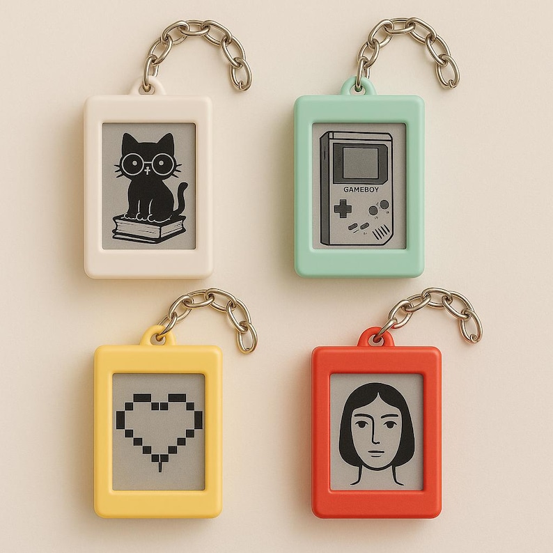Peut inclure: Quatre porte-cl&eacute;s rectangulaires en blanc, vert menthe, jaune et rouge. Chaque porte-cl&eacute;s a une cha&icirc;ne argent&eacute;e et un graphisme diff&eacute;rent : un chat avec des lunettes, une Gameboy, un c&oelig;ur pix&eacute;lis&eacute; et un visage de femme.