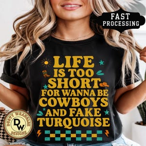 🤠✨ Sassy, bold, and boutique-perfect — this “Life is Too Short for Wanna Be Cowboys and Fake Turquoise” tee is made for cowgirls who like to keep it real. With playful retro lettering, doodle accents, and a checkerboard detail, this shirt is equal parts funny and stylish.

Printed on genuine Comfort Colors® tees, it has that soft, vintage-inspired feel that Western girls love. Pair it with turquoise jewelry, cutoffs, and boots for the ultimate rodeo-ready look.