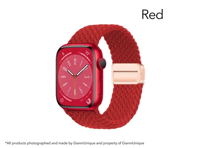 May include: A red smartwatch with a rectangular face and a matching red braided strap. The watch features a digital display with white hands and markers, a black side button, and a metallic rose gold-colored clasp on the woven band.