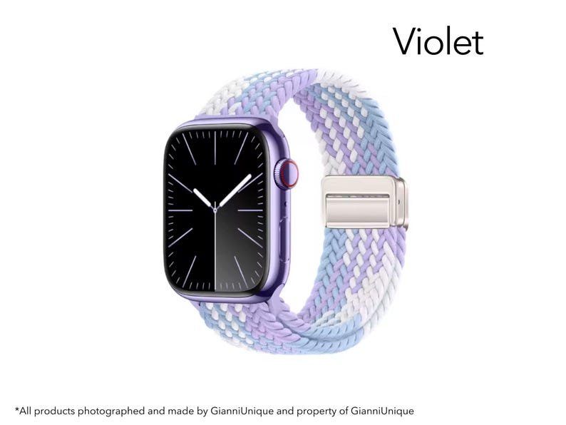 May include: A violet smartwatch with a black screen and a braided elastic band featuring a woven pattern of white, light blue, and lavender threads. The word Violet is printed in the upper right corner above the watch.