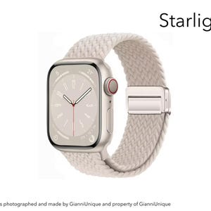 May include: A smartwatch with a rectangular screen displaying a clock face and a starlight-colored braided band. The watch case is a metallic light gold tone with a side crown featuring a red accent. The word Starlight is printed above the watch.