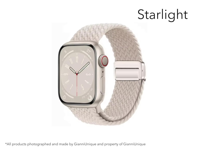 May include: A smartwatch with a rectangular screen displaying a clock face and a starlight-colored braided band. The watch case is a metallic light gold tone with a side crown featuring a red accent. The word Starlight is printed above the watch.