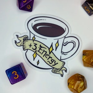Peut inclure: Un autocollant blanc avec une illustration de dessin animé d'une tasse de café avec le texte " +3 Energy" sur une bannière. L'autocollant est entouré de cinq dés, deux violets, trois dorés.