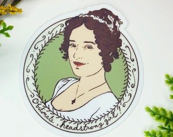 May include: A round sticker with a green background and a white border. The sticker features a line drawing of a woman with brown hair, wearing a white dress and a necklace. The text "Ultimate, headstrong girl!" is written around the border of the sticker.