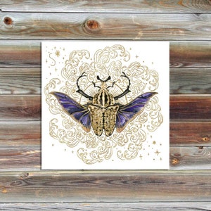 Puede incluir: Un escarabajo dorado y morado con las alas extendidas, rodeado de un diseño dorado en espiral intrincado sobre un fondo blanco.