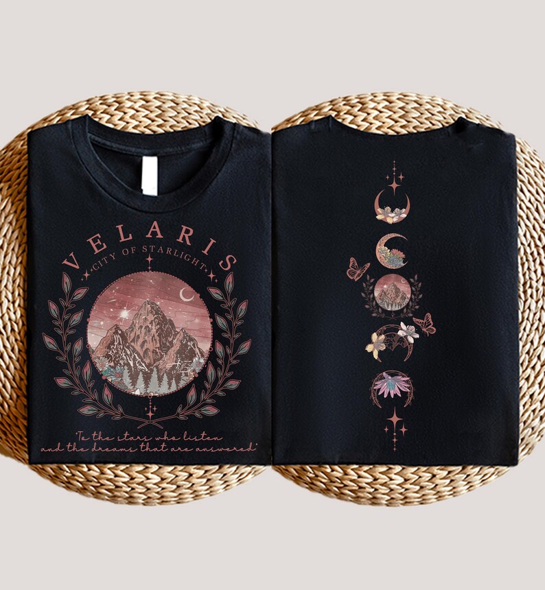 Velaris-themed pink t-shirt with front design of mountains, stars, and 'To the stars who listen' quote. Back highlights moon phases, butterflies, and floral art, blending celestial and fantasy vibes in a stylish, soft fabric.