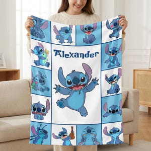 May include: A blue and white blanket featuring the character Stitch from Lilo & Stitch. The blanket has a grid pattern with various Stitch poses and the name "Alexander" in the center. The blanket is made of a soft material.