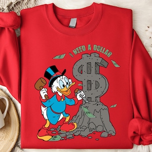 Hilarious Scrooge McDuck money tee for men and women who love cash, wealth, and success. This retro cartoon shirt features the famous duck diving into gold coins, making it a perfect gift for investors, finance lovers, and classic Disney fans!