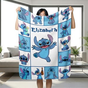 May include: A white and blue blanket featuring the character Stitch from Lilo & Stitch. The blanket has a grid pattern with various images of Stitch, and the name "Elizabeth" is printed in the center.