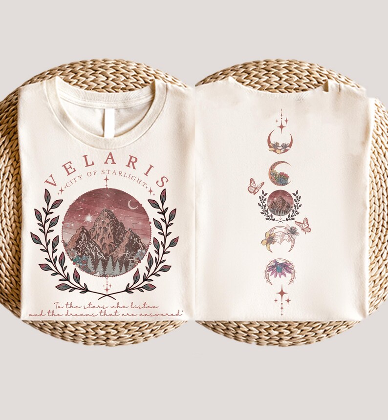 Velaris-themed pink t-shirt with front design of mountains, stars, and 'To the stars who listen' quote. Back highlights moon phases, butterflies, and floral art, blending celestial and fantasy vibes in a stylish, soft fabric.