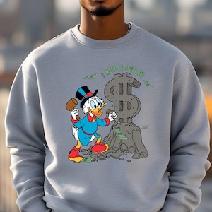 Hilarious Scrooge McDuck money tee for men and women who love cash, wealth, and success. This retro cartoon shirt features the famous duck diving into gold coins, making it a perfect gift for investors, finance lovers, and classic Disney fans!