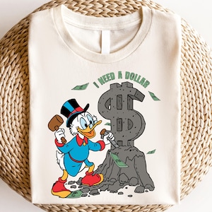Hilarious Scrooge McDuck money tee for men and women who love cash, wealth, and success. This retro cartoon shirt features the famous duck diving into gold coins, making it a perfect gift for investors, finance lovers, and classic Disney fans!