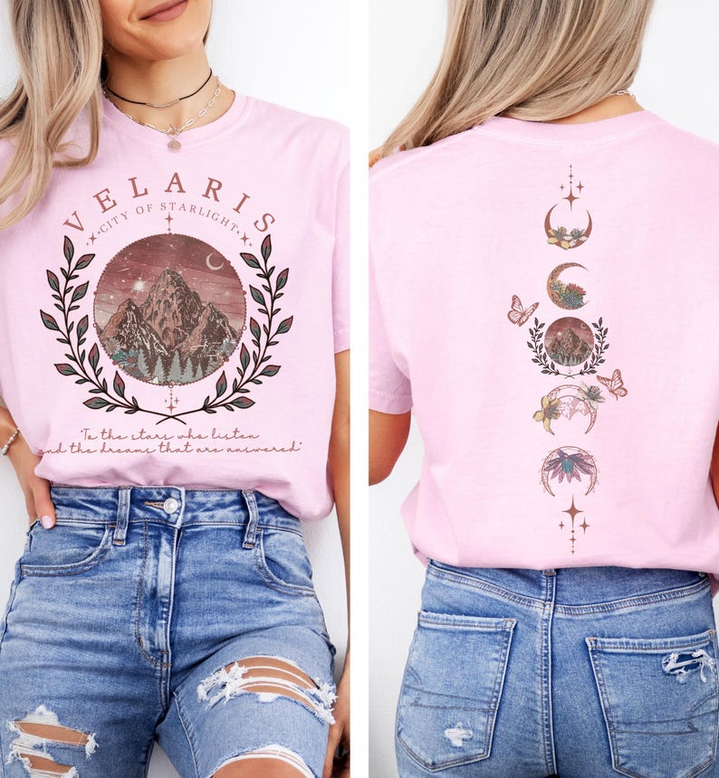 Velaris-themed pink t-shirt with front design of mountains, stars, and 'To the stars who listen' quote. Back highlights moon phases, butterflies, and floral art, blending celestial and fantasy vibes in a stylish, soft fabric.