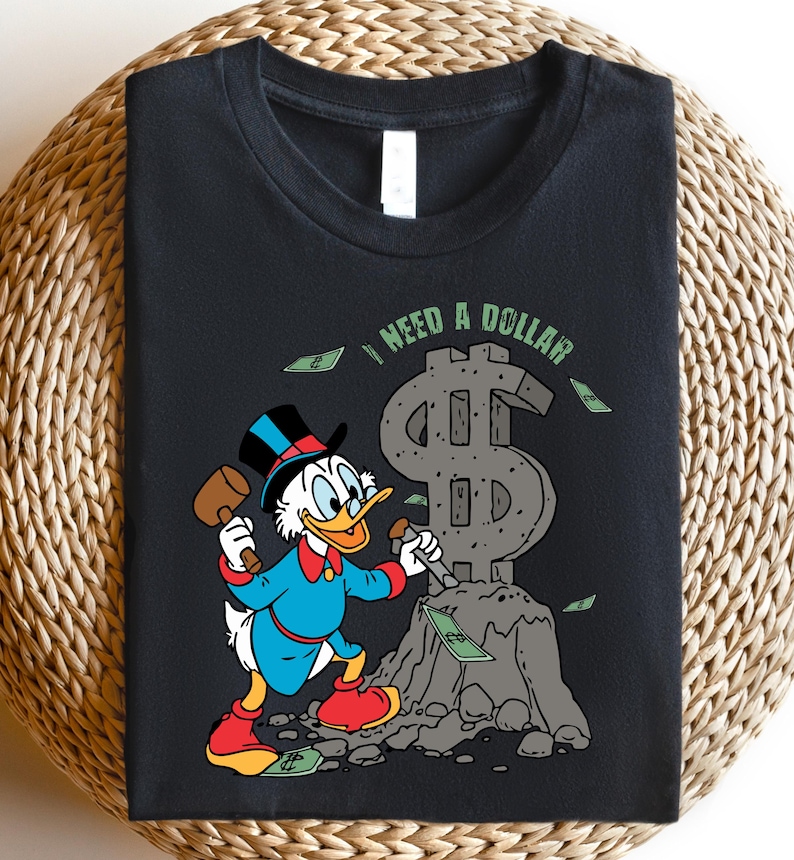 Hilarious Scrooge McDuck money tee for men and women who love cash, wealth, and success. This retro cartoon shirt features the famous duck diving into gold coins, making it a perfect gift for investors, finance lovers, and classic Disney fans!