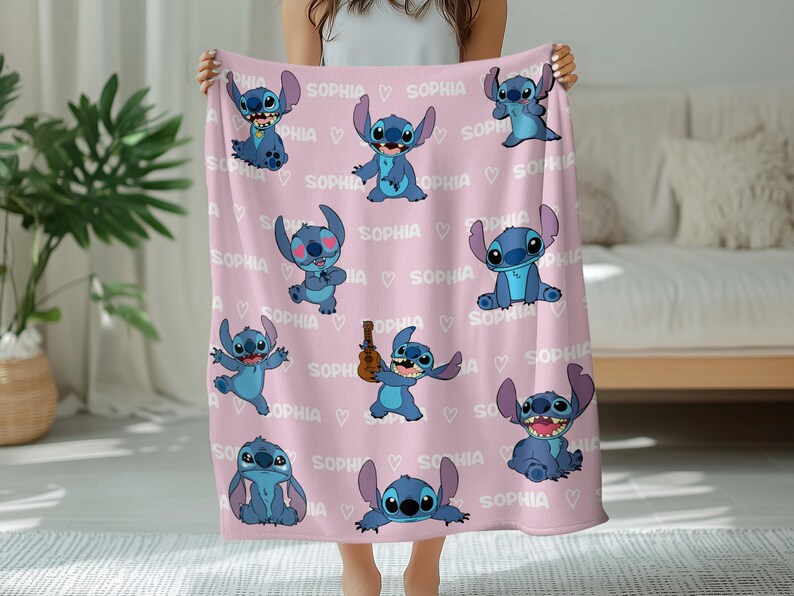 Peut inclure: Une couverture rose orn&eacute;e de plusieurs illustrations bleues de personnages de dessins anim&eacute;s et du nom "SOPHIA" r&eacute;p&eacute;t&eacute; avec des c&oelig;urs. La couverture est pr&eacute;sent&eacute;e, mettant en valeur le motif.