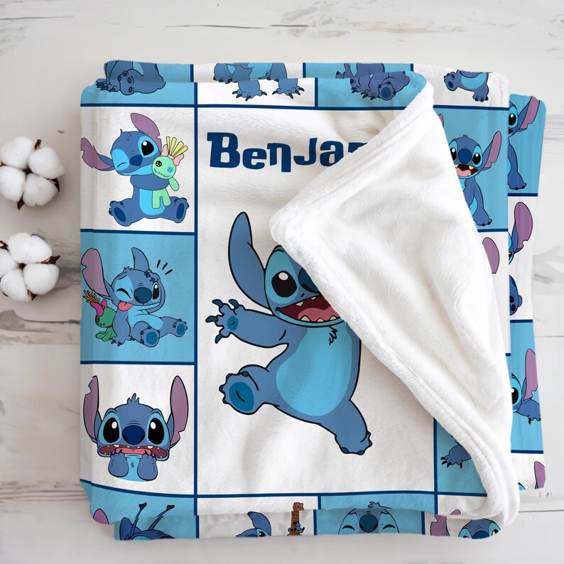 May include: A blue and white fleece blanket featuring the character Stitch from Lilo & Stitch. The blanket has a grid pattern with Stitch in various poses, and the name "Benja" is printed on the blanket.