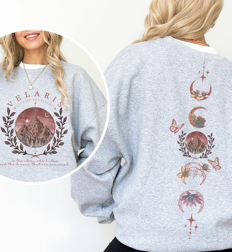 Velaris-themed pink t-shirt with front design of mountains, stars, and 'To the stars who listen' quote. Back highlights moon phases, butterflies, and floral art, blending celestial and fantasy vibes in a stylish, soft fabric.