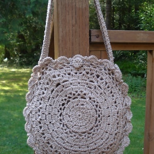 A crochet pattern from Nancy Brown-Designer - a pattern for a doily inspired round bag. Inspired by a simple to crochet doily, this bag is a fashion must-have. Two doilies are crocheted together with a gusset. A strap and button completes the look.