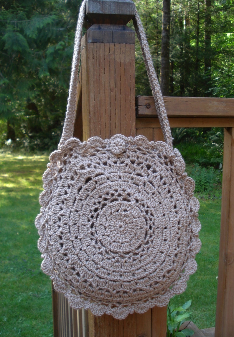 A crochet pattern from Nancy Brown-Designer - a pattern for a doily inspired round bag. Inspired by a simple to crochet doily, this bag is a fashion must-have. Two doilies are crocheted together with a gusset. A strap and button completes the look.