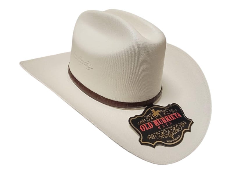 Puede incluir: Sombrero de vaquero blanco roto con una banda de cuero marr&oacute;n y un ala curvada. El sombrero presenta la etiqueta "OLD MURRIETA HATS". Este sombrero de estilo western es adecuado para uso casual y formal.