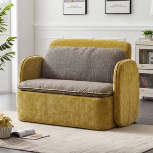 May include: A mustard yellow loveseat with a gray seat cushion and backrest. The loveseat has rounded armrests and a low profile. The seat cushion is bordered with a thin, light yellow trim. The loveseat is placed on a light-colored rug.