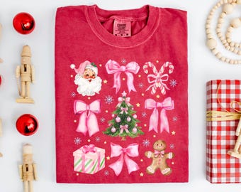 Maglietta natalizia Comfort Colors® Coquette, maglietta estetica con fiocco di Babbo Natale rosa, graziosa maglietta con grafica natalizia, outfit natalizio vintage per ragazze