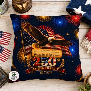 May include: A decorative pillow with a patriotic theme. It features an American flag, a soaring eagle, and fireworks against a dark blue starry background. The pillow commemorates the 250th anniversary of the Declaration of Independence.