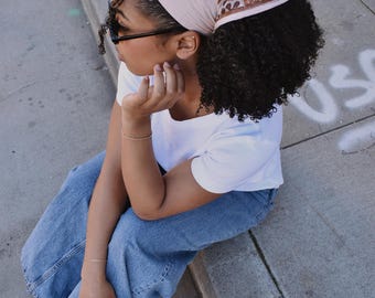 Pañuelo tipo bandana de algodón beige con estampado de bloques y borde estampado floral marrón.