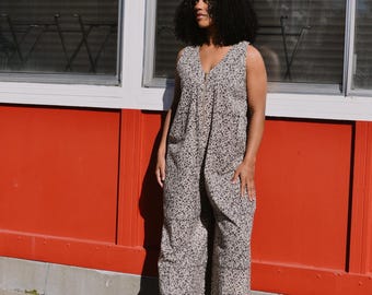 Mono de algodón con estampado de bloques: estampado floral en blanco y negro, sin mangas, cremallera frontal, bolsillos.