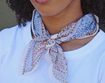 Pañuelo tipo bandana de algodón estampado en bloques en azul, rojo y amarillo con estampado floral.