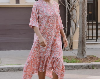 Vestido midi rosa con volantes y estampado floral.