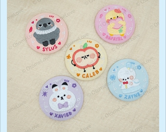 May include: A collection of five embroidered circular patches. Each patch features a different cartoon character, including a bird, a chick, an apple, a bunny, and a bear. Each patch has a name embroidered on it: Sylus, Rafael, Caleb, Xavier, and Zayne.