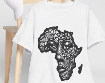 May include: White t-shirt featuring a black graphic of the African continent stylized as a face with intricate patterns. A white baseball cap rests on a wooden chair. The shirt hangs on a wooden hanger.