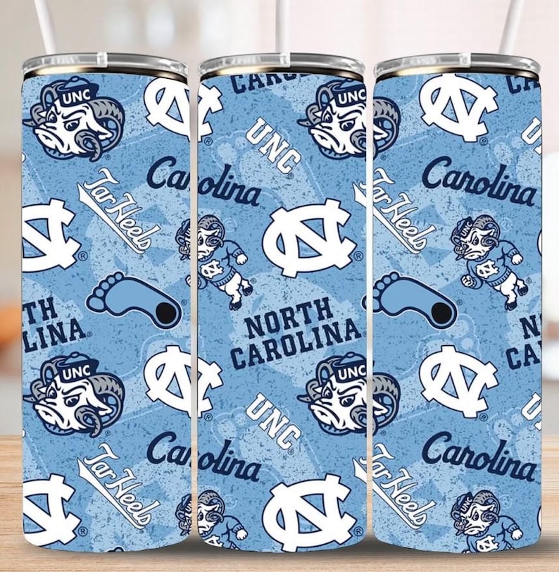 May include: A set of three blue and white insulated tumblers with a repeating pattern of the UNC Tar Heels logo, a ram mascot, and the words "Tar Heels" and "Carolina".