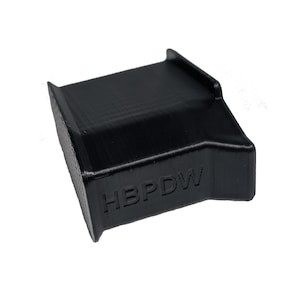 May include: A black, rectangular 3D-printed object with a textured surface. The object has a curved top and the letters "HBPDW" are embossed on the side. The item is set against a white background.