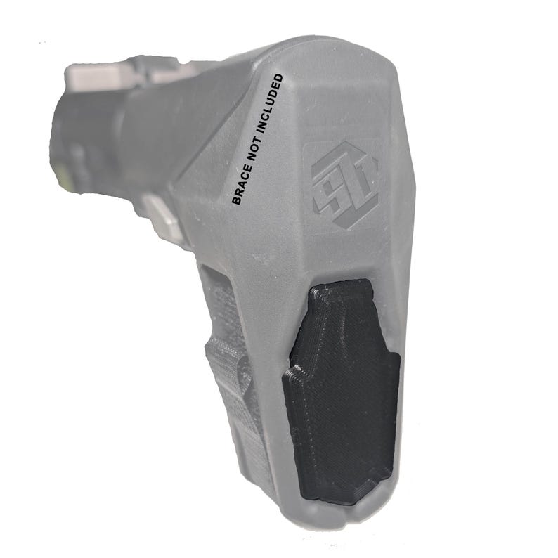 May include: A gray firearm accessory with a black grip. The text "BRACE NOT INCLUDED" is printed on the side. The accessory has a textured surface and a geometric design.