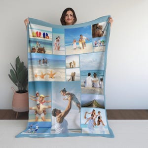 Op de afbeelding: Een lichtblauwe deken met een collage van strandvakantiefoto's. De afbeeldingen tonen gezinnen, zeesterren en strandtaferelen. De deken heeft een lichtblauwe rand en wordt door een persoon vastgehouden.