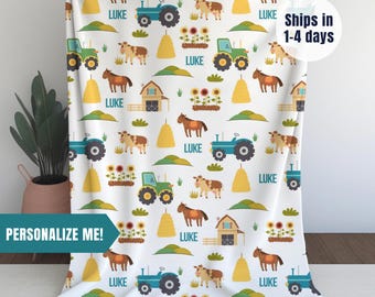 May include: White personalized baby blanket with a repeating pattern of farm animals, tractors, hay bales, and sunflowers. The name "LUKE" is repeated throughout the design.