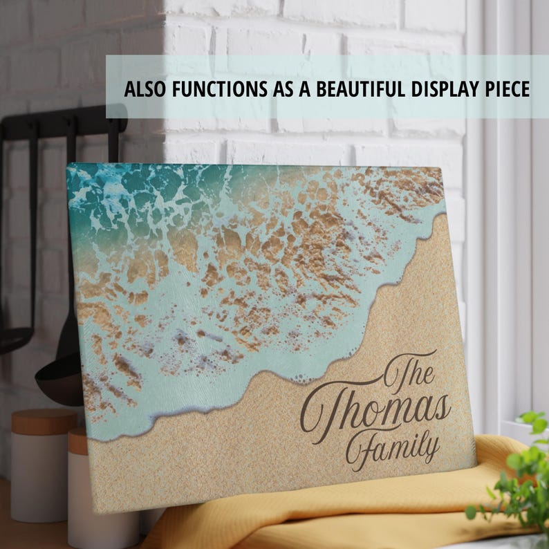 K&ouml;nnte beinhalten: Ein braunes und beiges Schneidebrett mit einem blauen und wei&szlig;en Wellendesign. Der Text "The Thomas Family" ist auf das Brett gedruckt.