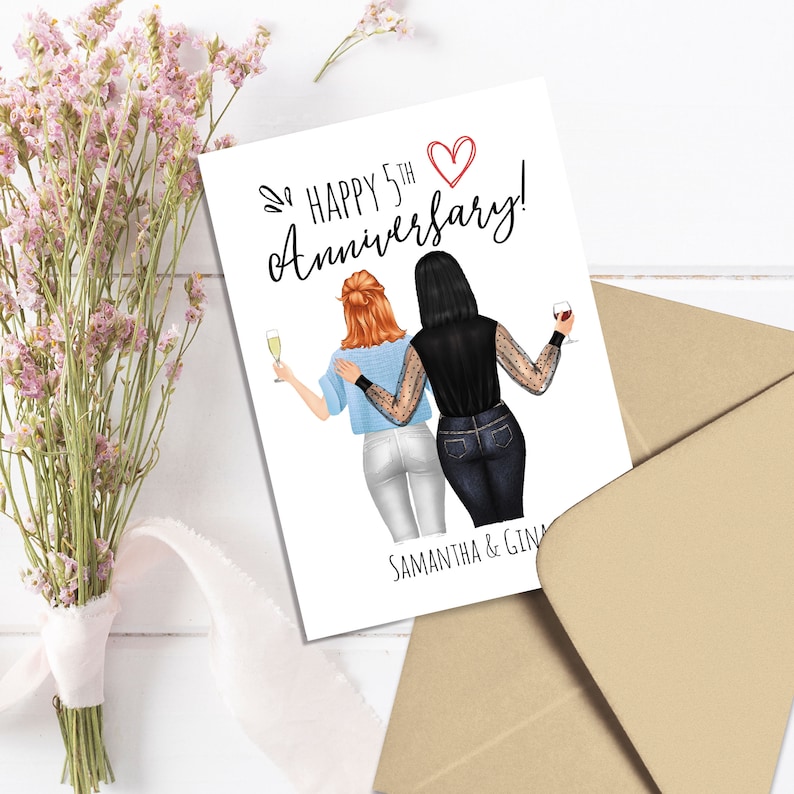 May include: A greeting card with the text "Happy 5th Anniversary!" and the names "Samantha & Gina." The card features an illustration of two people toasting with champagne and wine. A bouquet of pink flowers and a brown envelope are also in the image.