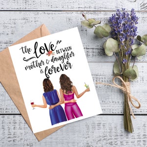 May include: A greeting card with the text "the love between mother & daughter is forever" and an illustration of two women. The card is accompanied by a brown envelope, a bouquet of lavender, and eucalyptus leaves.