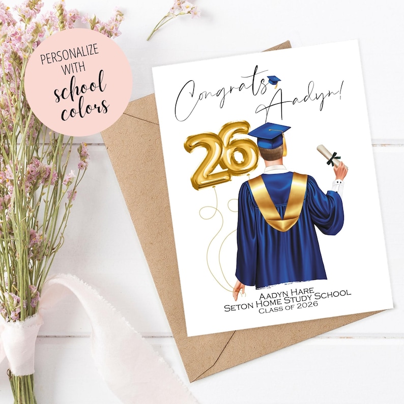 May include: A graduation card featuring a graduate in a blue gown with gold accents, holding a diploma. Gold balloon numbers '26' are included. The card reads 'Congrats Aadyan!' and 'Class of 2026'. A pink circle says 'Personalize with school colors'.