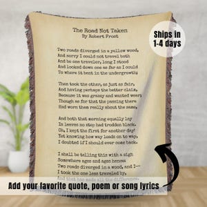 May include: A woven throw blanket with a beige background and brown and black woven threads. The blanket features the poem "The Road Not Taken" by Robert Frost. The poem is printed in black text. The text "Ships in 1-4 days" is printed in the top right corner of the blanket. The text "Add your favorite quote, poem or song lyrics" is printed at the bottom of the blanket.