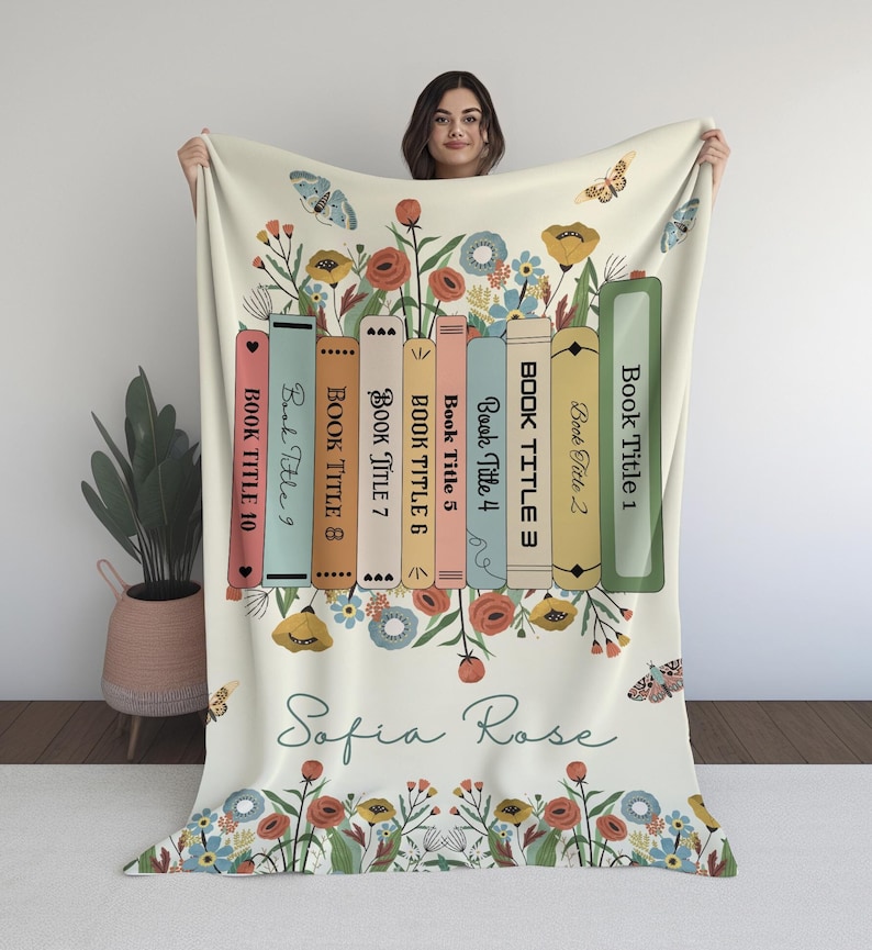 May include: A white throw blanket with a floral design and a row of books with the titles "Book Title 1" through "Book Title 10". The blanket also has the name "Sofia Rose" written in cursive.